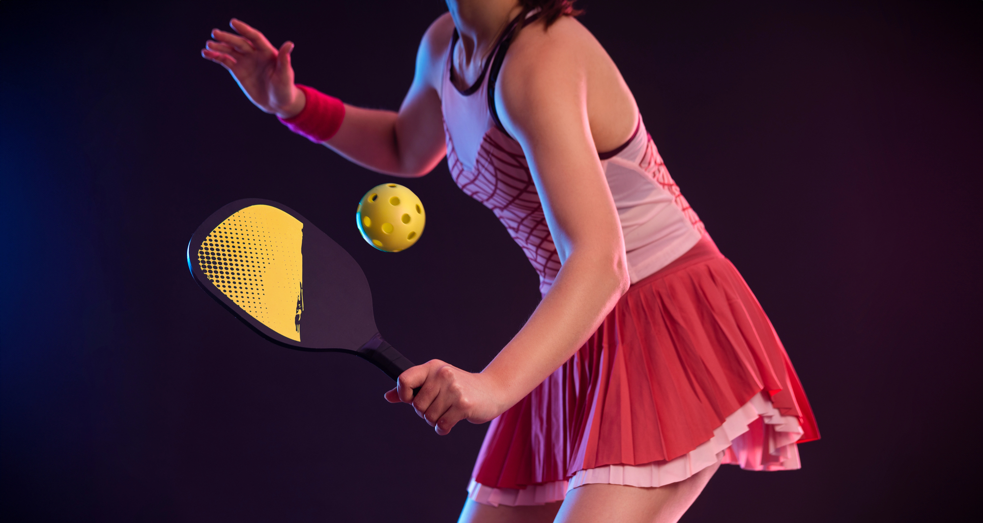 Pickleball player with racket on the court. Sport court and balls.