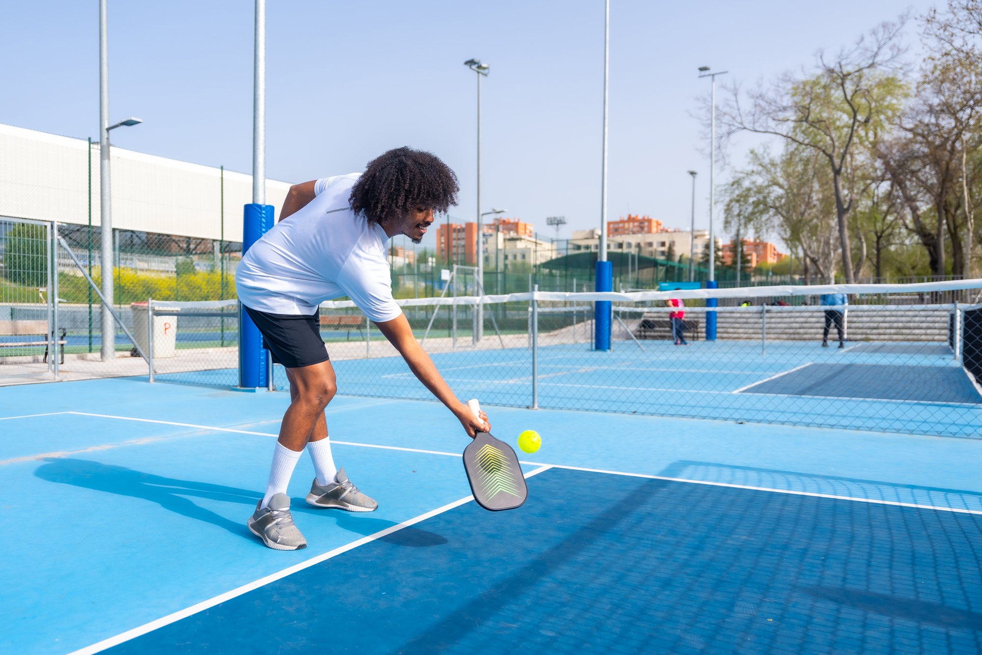 Friends Playing Pickleball Together In An Outdoor Court