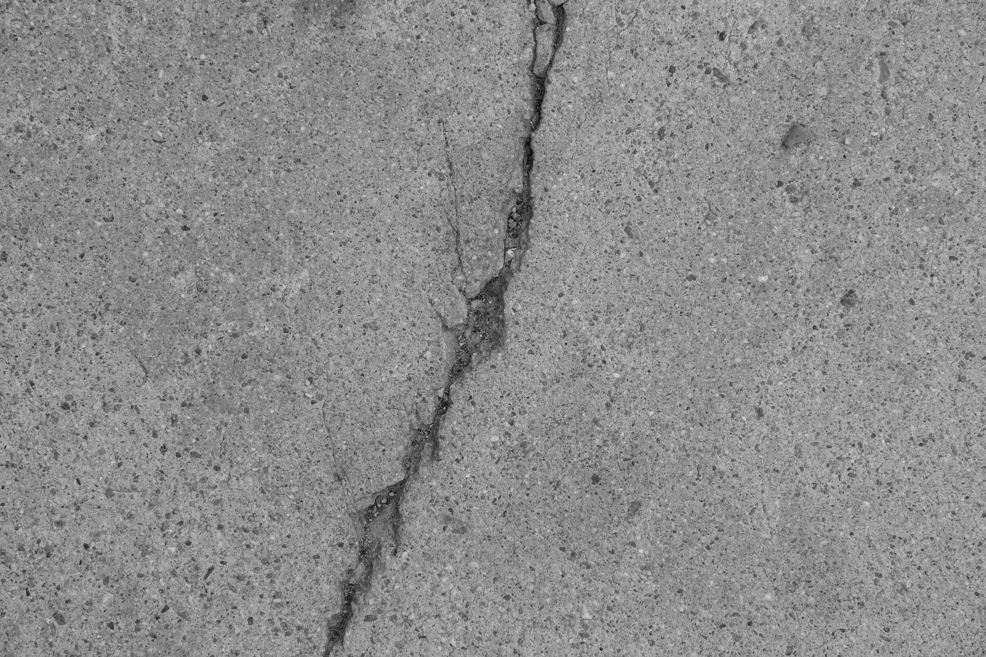Close-up crack in cracked outdoor court pavement