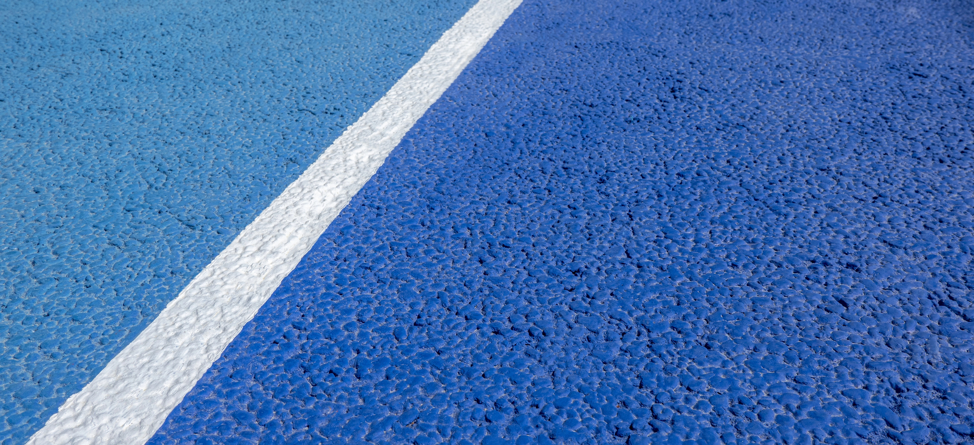 Abstract diagonal white line on a blue pickleball court surface